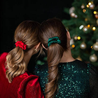 Comparison of red and pine green silk hair scrunchies worn in the hair of two different women
